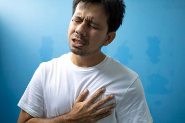 Genç Asyalı adam göğüs ağrısı çekiyor.