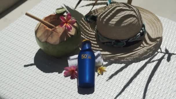 巴厘岛的绿色椰子与竹杆 防晒霜Spf 太阳帽 热带粉红花 白色日光浴床上的棕榈树荫紧密相连的视频镜头 — 图库视频影像