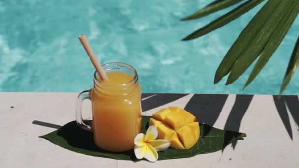 Videoaufnahmen Von Einmachglas Mit Mangosaft Bambusstroh Der Hälfte Frischer Mango — Stockvideo