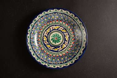 Siyah arkaplanda Etnik Özbek seramik sofra takımı. Dekoratif seramik tabak.