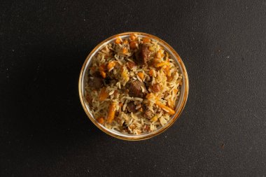 Pilaf, siyah bir masada seramik tabaklarda kuzu eti, biftek ve sebzeli geleneksel bir pirinç tabağıdır..