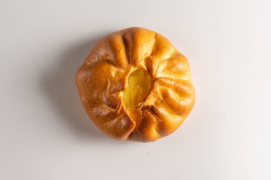 Süzme peynirli taze buğday ekmeği. Tereyağlı tatlı un pastanesi ürünü, beyaz arka planda kaymak doluyor..