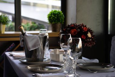 Kafedeki buz kovasında bir şişe şampanya ya da köpüklü şarap. Ya da birkaç konuk için restoran masası. Sığ alan derinliği, bulanık arkaplan