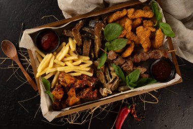 Birkaç kişilik bir şirket için büyük bir paket bira. Patates kızartması, tavuk nugget, çavdar ekmeği, domuz kulağı, tavuk bacağı, kebap ve ketçap..