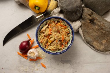 Geleneksel desenli Özbek ulusal kasesinde tavuk filetosu ile sıcak pilav. Haşlanmış pirinç, et ve baharatlı sebzelerden yapılmış klasik bir doğu yemeği..