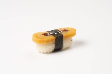 Suşi nigiri domates. Haşlanmış pirinç, nori, susam tohumu ve beyaz tabakta teriyaki soslu Japon omleti..