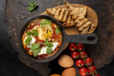 Şef usülü shakshuka. Klasik bir İsrail yumurtası. Domates, acı biber, soğan ve baharat sosunda kızartılmış. Kasher yahudi mutfağı..