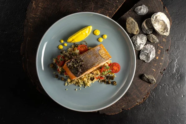 Kuskus, kiraz domatesleri, otlar ve limon sosuyla süslenmiş ızgara somon. Sıcak bir balık ve mısır gevreği..