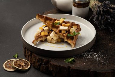 Muz, mango, karamel ve naneli Viyana waffle 'ı. Klasik sıcak Belçika waffle 'ı..