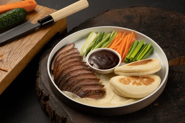 Peking duck with fresh bao bun. Traditional Chinese dish of poultry and vegetables fillet with teriyaki sauce.