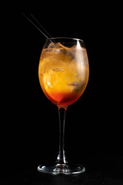 Alkol kokteyli Fiero spritz. Az alkollü martini, cin tonik, portakal ve buzlu siyah arka planda şeffaf bir bardak..