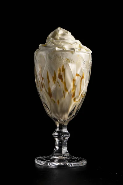 Muzlu, karamelli ve kremalı klasik milkshake. Siyah arka planda. Protein tatlı kokteyli. Soğuk içecek..