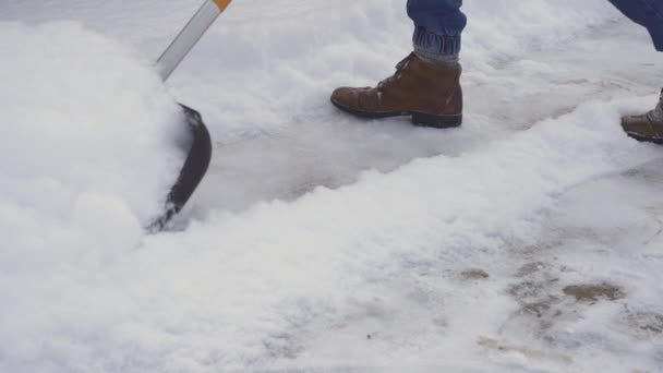 Déneigement des dérives sur le trottoir avec une pelle à neige gros plan. — Video