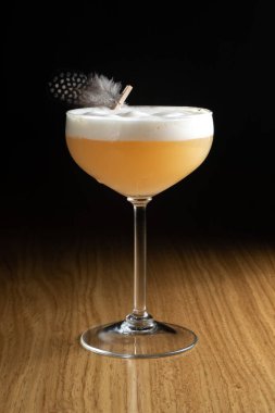 Viski kokteyli, viski ve limon suyuna dayanan, şeffaf bir bardakta bıldırcın tüyü ile süslenmiş, ahşap bir masada bulunan alkollü bir kokteyl..