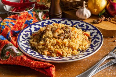 Pilaf with lamb. Traditional oriental hot dish of boiled rice, lamb, vegetables and spices in a plate with national Uzbek ornaments. clipart
