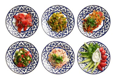 Geleneksel Özbek desenli tabakta salata ve soğuk mezeler. Doğu mutfağının soğuk yemekleri beyaz arka planda