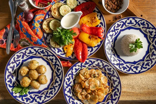 Bir çift meze. Geleneksel Özbek yemeklerinde ızgara sebze, haşlanmış pirinç ve fırında patates..