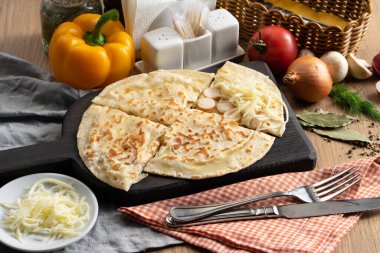 Tahta kesme tahtasının üzerinde sosisli ve mozzarella peynirli düz ekmek.
