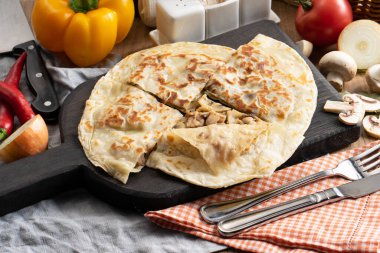 Mantarlı tortilla ve tahta kesme tahtasındaki soğan.