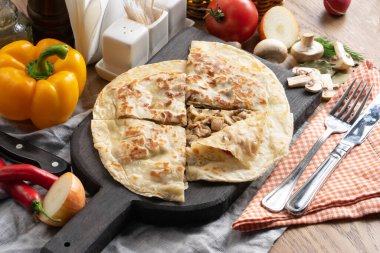 Mantarlı tortilla ve tahta kesme tahtasındaki soğan.
