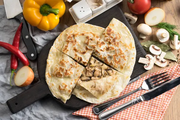Mantarlı tortilla ve tahta kesme tahtasındaki soğan.