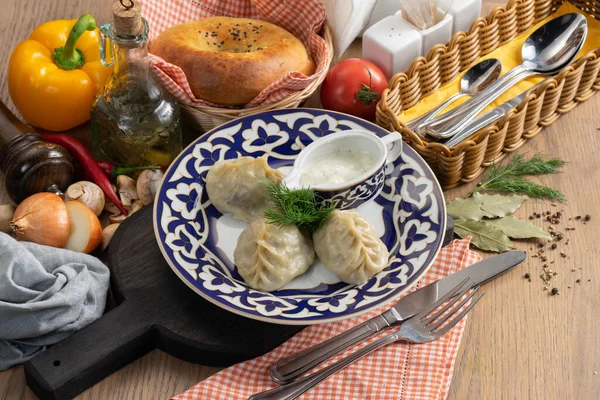 Geleneksel Özbek desenli bir tabakta kuzu eti, ekşi krema ve dereotu.