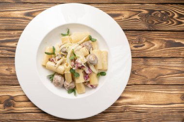 Köfteli Rigatoni makarna ve beyaz seramik tabakta beşamel sosu.