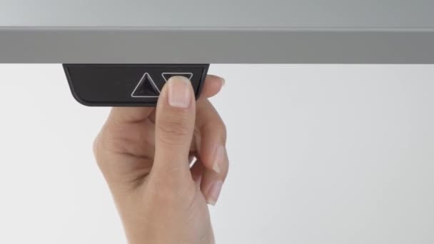 Die Frau lässt einen grauen Schreibtisch unterschiedlicher Höhe für Steharbeiten herunter — Stockvideo