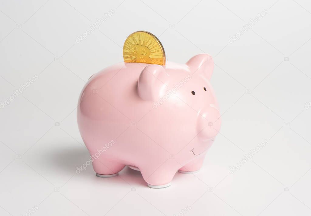 A classic pink piggy bank with a cryptocurrency symbol - a bitcoin gold coin