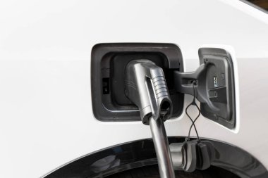 Bir güç ünitesine bağlı modern bir elektrikli araba hızlı şarj istasyonunda pilleri şarj eder.