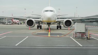 Turuncu GPU kablosu üzerinden elektrik alan yolcu uçaklarının doğrudan görüntüsü. Uçuş öncesi teknik dönüş servisi sırasında terminale park edilmiş sabit bir uçak..