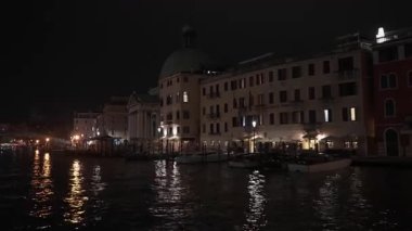 Venedik Büyük Kanalı geceleri aydınlatılmış San Simeone Piccolo kilisesi ile. Tarihi yapılar ve Scalzi köprüsü karanlık suları yansıtır. Seyahat sırasında İtalya 'da manzaralı şehir akşam manzarası.