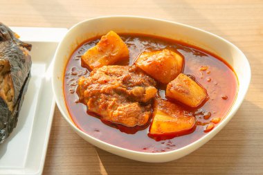 Tayland tavuğu, köri, Tayland tavuğu ve Hint cevizi sütü ve baharatlı patates, beyaz pirinçle yenir.