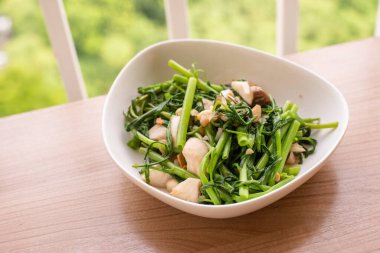 Kızarmış yeşil sabah zaferini sarımsak ve mantarla karıştır.