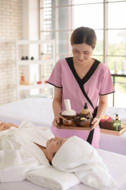 Spa terapisti müşterisini rahat bir odada tedavi etmek için kozmetik hazırlayın.