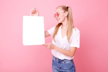 Stüdyoda elinde beyaz bir kese kağıdıyla manken.