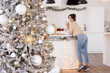 Yeni yılda mutfakta fincanı olan bir kız.