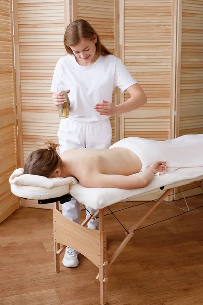 Masör yağ ile masaj yapar.