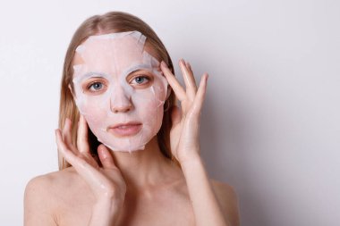 Yüzünde yeni bir kozmetik maske olan bir kız.