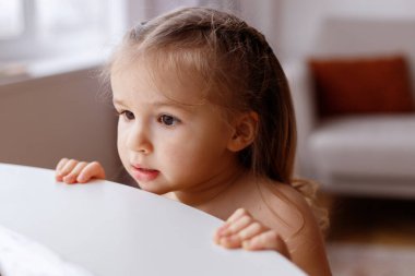 Küçük kız masaya yan bakıyor.