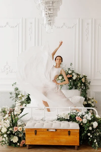 Attraktive Tänzerin Weißen Kleid Auf Dem Bett Mit Blumen — Stockfoto