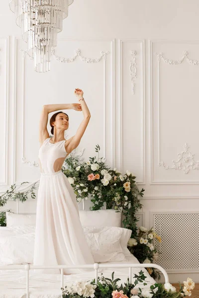 Tänzerin Weißen Kleid Auf Dem Bett Mit Blumen Der Lichthalle — Stockfoto
