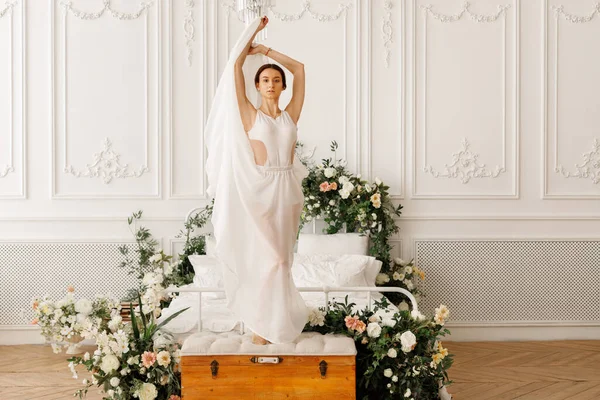 Attraktive Tänzerin Einem Eleganten Kleid Auf Einem Bett Mit Blumen — Stockfoto