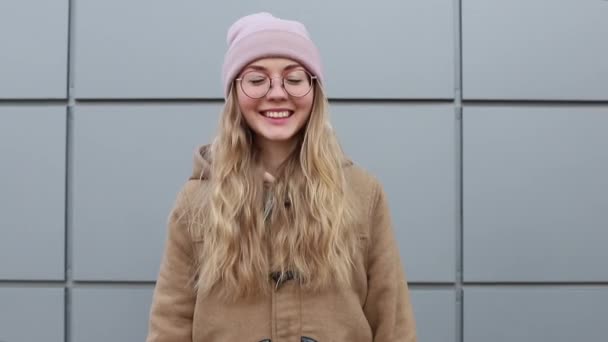 Blonde Mit Mütze Und Brille Nickt Und Stimmt Einem Grauen — Stockvideo