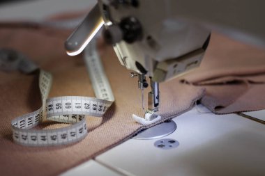 Kumaş ve mezura ile dikiş makinesi