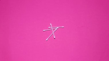 Pembe kozmetik arka planda kulak çubukları