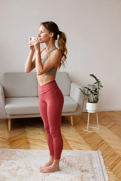 Sportvrouw Leggings Drinkt Water Woonkamer — Stockfoto