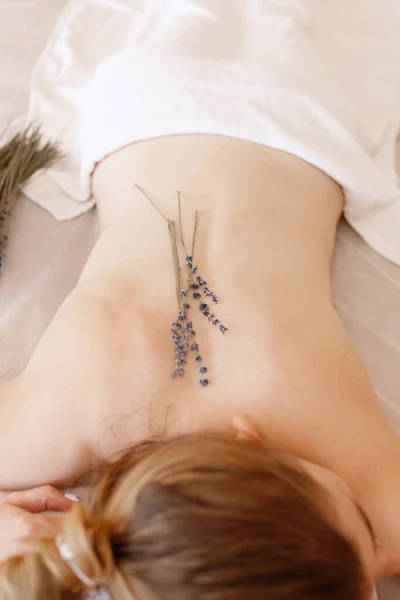 Genç kadın lavanta masajıyla geri döndü.