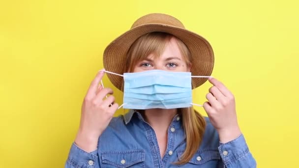 藁帽子の女の子が使い捨てのマスクをして授業を見せます 伝染病の間に — ストック動画