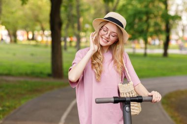 Yazın parkta motosikletli şapkalı genç bir kız.